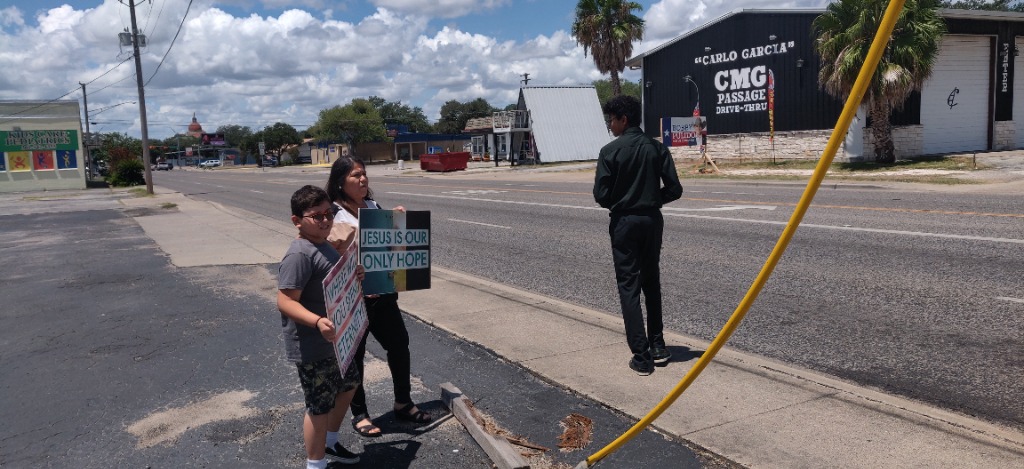 Church members holding Gospel signs in Beeville